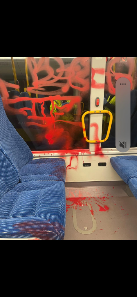 Hærget buskabine med rød graffiti spraymaling